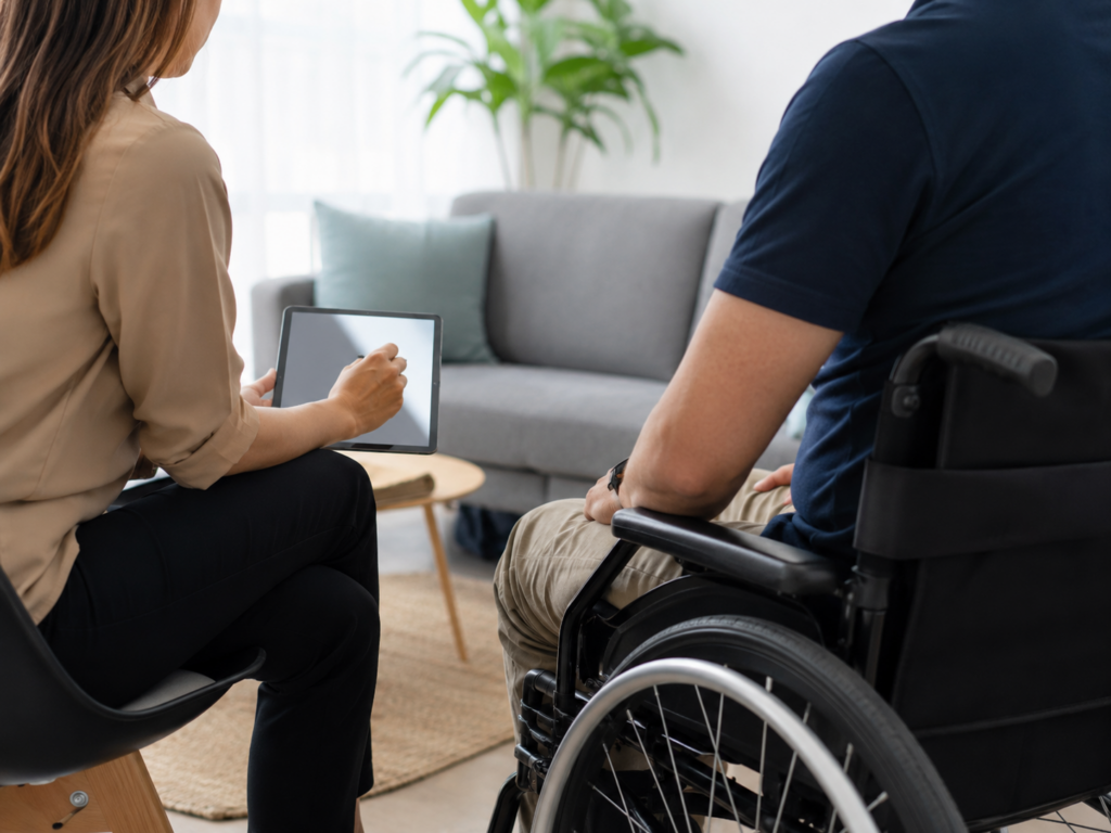Therapist answering a client’s questions during a mobile rehabilitation consultation at home